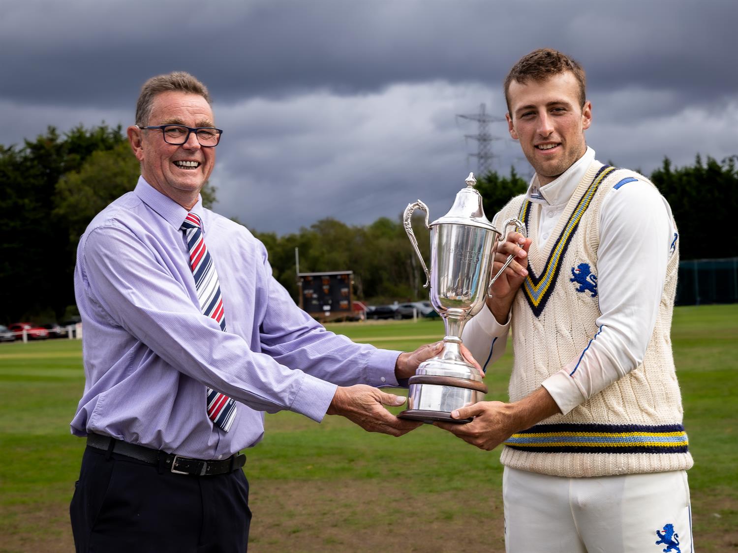 NCCA President Phil Caley presents the NCCA Cluberly Championship Trophy to Devon's captain James Horler following their victory in the Final against Buckinghamshire at West Bromwich Dartmouth Cricket Club.