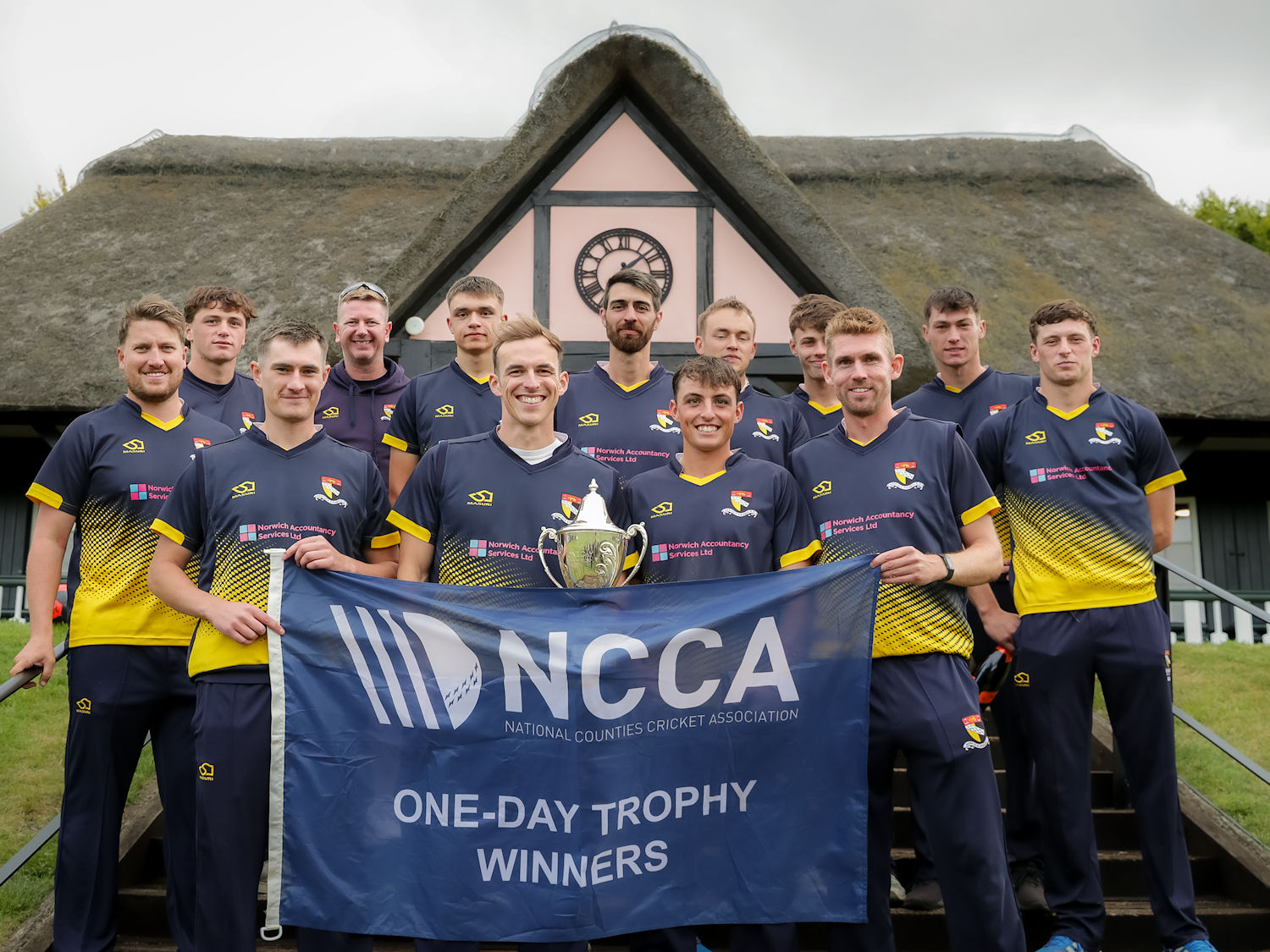 The victorious Norfolk squad with the NCCA Trophy in front of the pavilion at Wormsley Cricket Ground after their victory against Cheshire on August 25th, 2024.