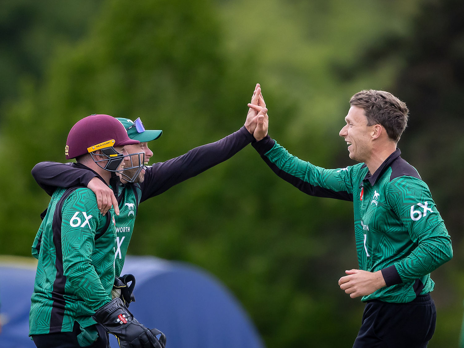 Wiltshire's Jack Mynott right is congratulated by Ben Draper and Jake Lintott after taking the wicket of Cheshire's Harry Dearden in the NCCA Trophy match at Marlborough College on May 4th, 2025.