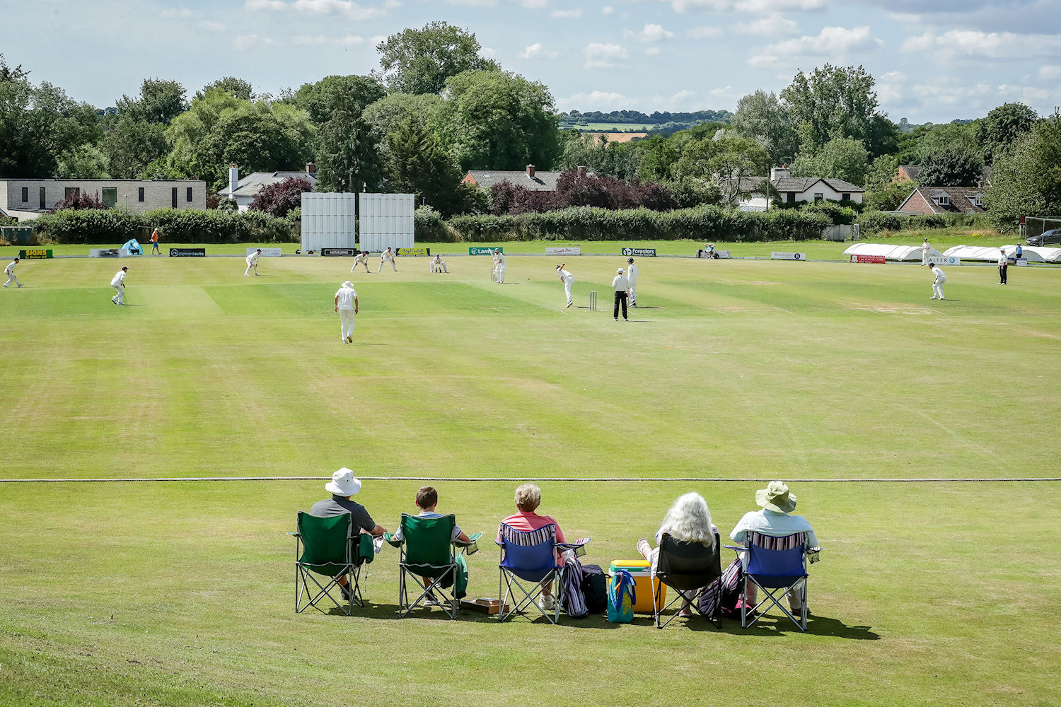 Spectators watching from the boundary as Ben Roberts bowls to Dylan Church on the first day of the Durant Cricket National Counties Championship match between Wiltshire and Shropshire at South Wilts Cricket Club on July 28th, 2024.