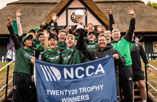 The Berkshire squad celebrating with the NCCA Dojo T20 Trophy in front of the pavilion at Wormsley Cricket Ground on August 30th, 2026.